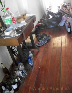 bottles of beer and trash in a messy student apartment