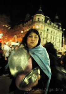 a woman banging a pot in a protest in Buenos Aires