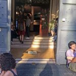 A group of students chat and one reads a book at the entrance to a university in Buenos Aires